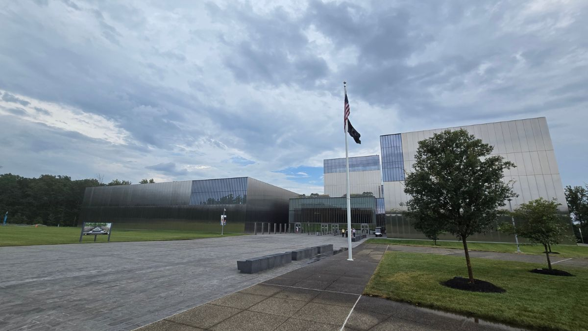 Exterior view of the National Museum of the United States Army at Fort Belvoir, Virginia, featuring its modern reflective architecture and flagpole.