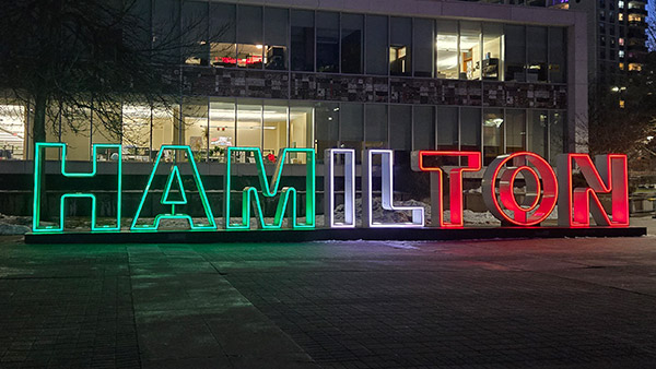 Hamilton sign lit up at night in front of City Hall in downtown Hamilton Ontario near Sheraton Hamilton Hotel