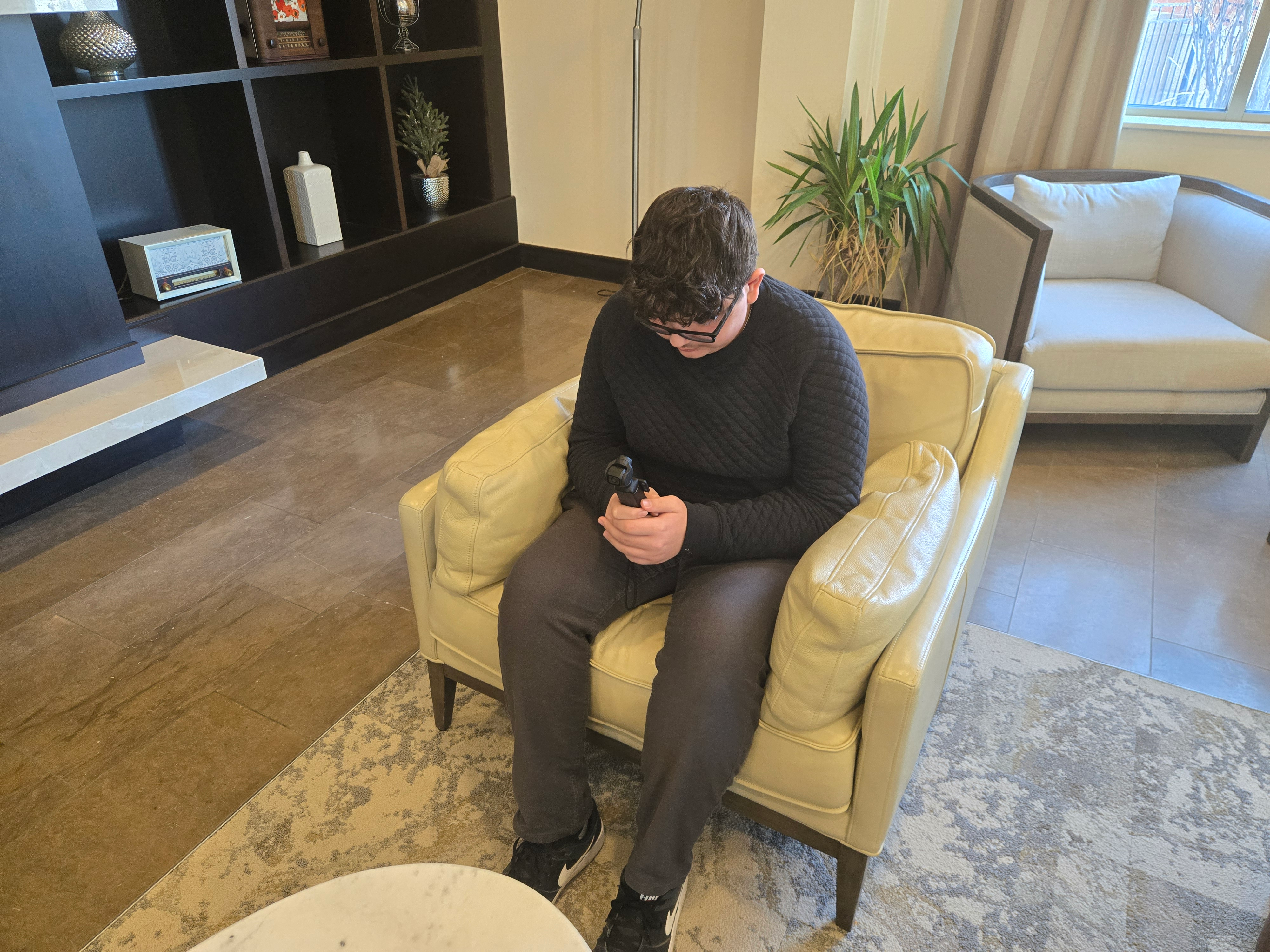 Mateo reviewing hotel footage for his teen hotel perspective in a hotel lounge